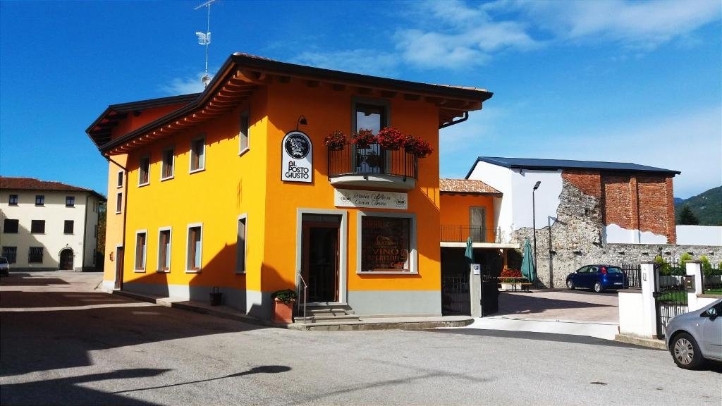 Facciata gialla di Al Posto Giusto a Nimis, con ingresso affacciato sulla strada.